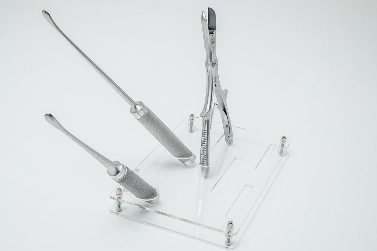 Instrumento largo y pinzas articuladas sobre soporte transparente