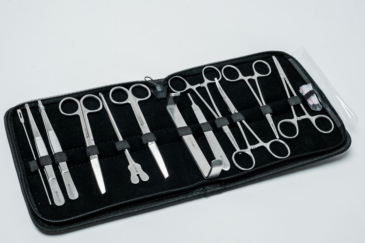 Estuche negro abierto con instrumentos quirúrgicos organizados