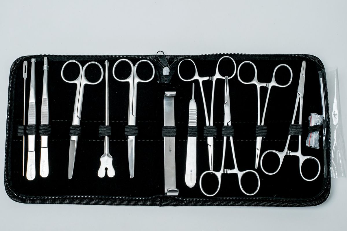 Vista frontal de un estuche abierto con tijeras, pinzas y otros instrumentos